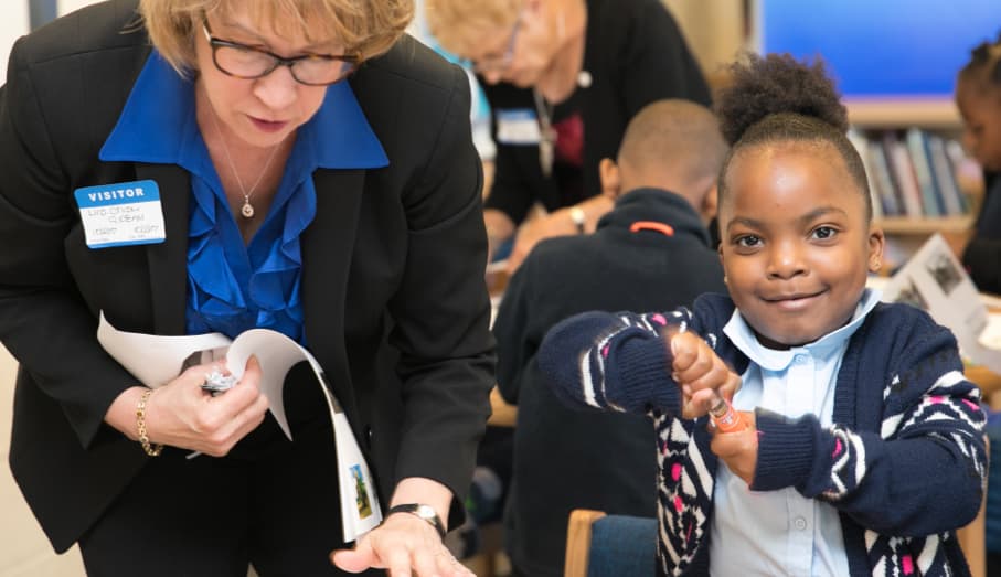 An ag literacy volunteer helps a young child