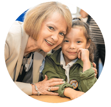 A helpful volunteer is teaching ag literacy to a young girl